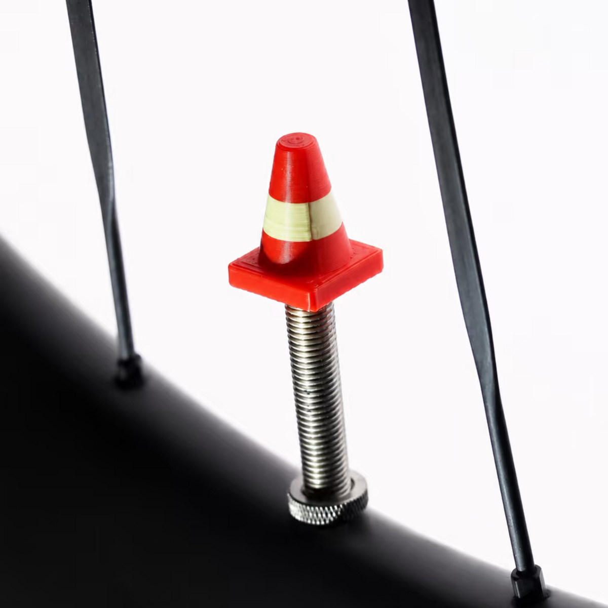 Tiny Detour Road Cone valve cap installed on a bicycle wheel